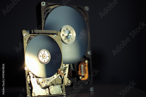 Disassembled hard drive from the computer with mirror effect. Opened hard drive from the computer hard disk drive (HDD)