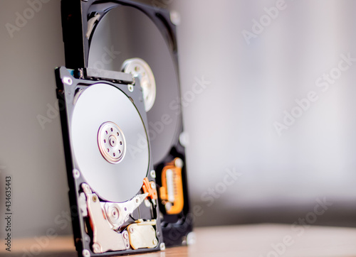 Disassembled hard drive from the computer with mirror effect. Opened hard drive from the computer hard disk drive (HDD)