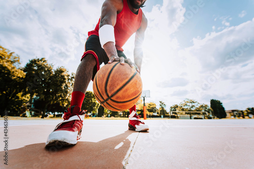 Basketball street player dribbling with ball on the court - Streetball, training and activity concept © Davide Angelini