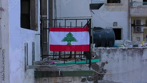 Beirut, Lebanon, 2020: day drone shot reveal going down of the destruction of buildings  due to the 4 August explosion with lebanon flag hanged on the balcony photo