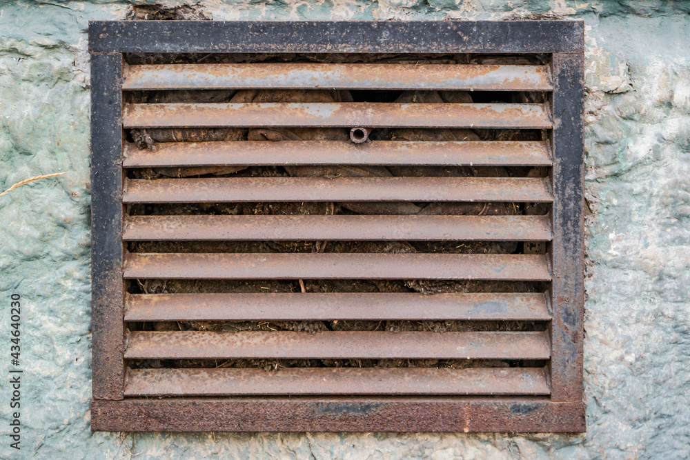Old rusty metal ventilation grate. Building exterior element. Old rusty metal ventilation grate. Building exterior element.