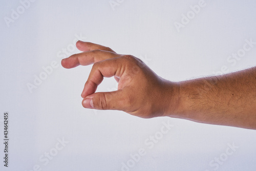Foto Mano de hombre adulto latino haciendo un gesto en un fondo blanco