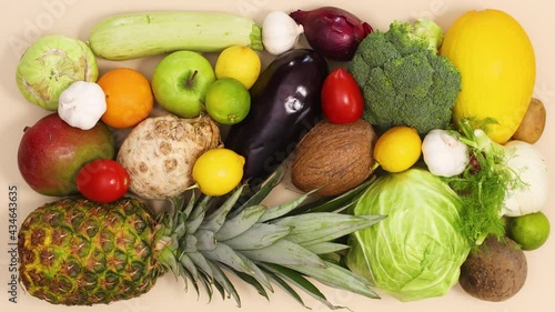 Fresh ripe and organic fruits and vegetables appear and filling the background. Stop motion flat lay