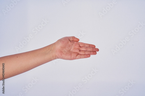Mano de hombre adulto latino haciendo un gesto en un fondo blanco