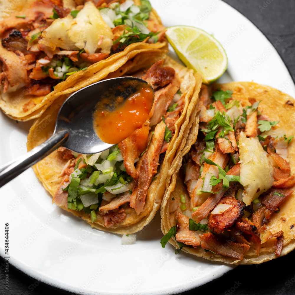 Pork tacos called al pastor with pineapple on dark background. Mexican tacos Pork tacos called al pastor with pineapple on dark background. Mexican tacos