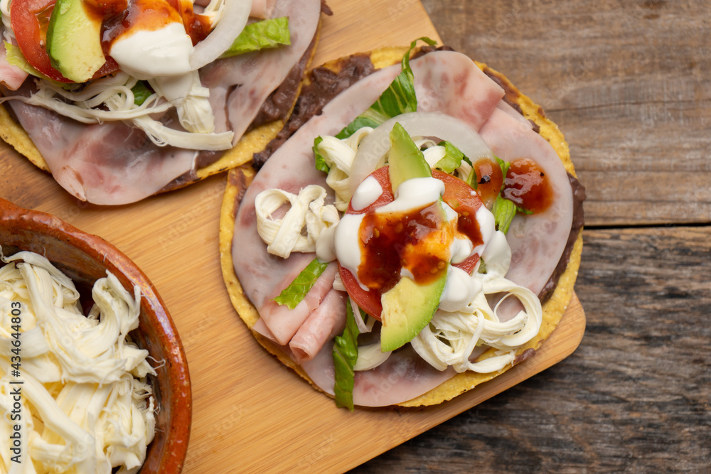 Corn toast with ham and Oaxaca cheese on wooden background. Mexican food Corn toast with ham and Oaxaca cheese on wooden background. Mexican food