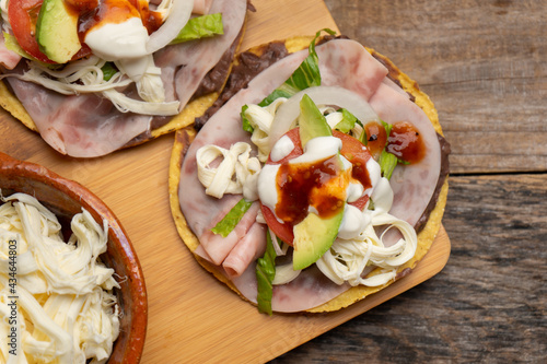 Corn toast with ham and Oaxaca cheese on wooden background. Mexican food