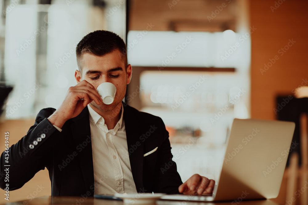 Happy business man sitting at cafeteria with laptop and smartphone Happy business man sitting at cafeteria with laptop and smartphone