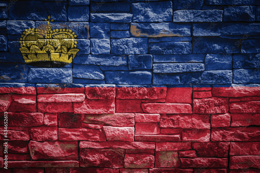 National flag of Liechtenstein on stone wall background.The concept of national pride and symbol of the country. Flag banner on stone texture background. National flag of Liechtenstein on stone wall background.The concept of national pride and symbol of the country. Flag banner on stone texture background.