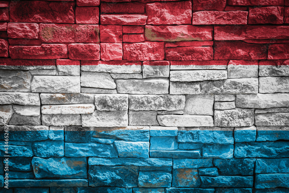 Fototapeta premium National flag of Luxembourg on stone wall background.The concept of national pride and symbol of the country. Flag banner on stone texture background.