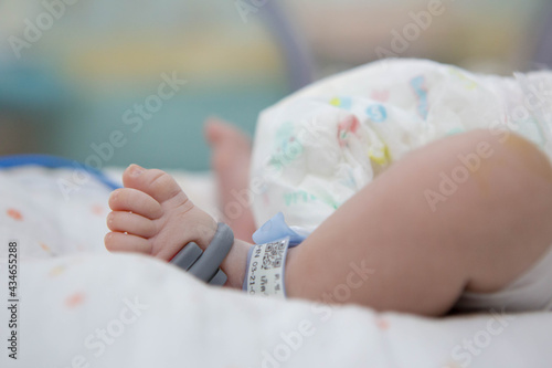 Foot of Asian newborn baby in the delivery room at hospital. In the newborn incubator is A medical device used to regulate the temperature of a newborn baby to be healthy according to the criteria