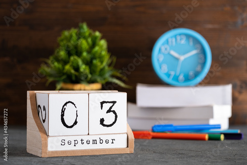 September 03rd. September 03 wooden cube calendar with blur objects on background. photo