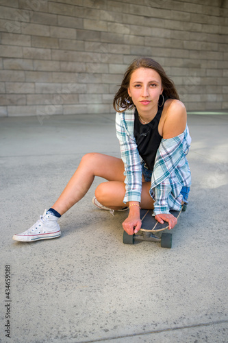 Young Woman Posing with Her Skateboard in an Urban Setting