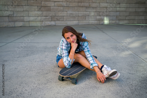 Young Woman Posing with Her Skateboard in an Urban Setting