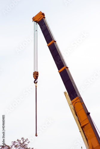 retractable boom of a truck crane against the background of the sky