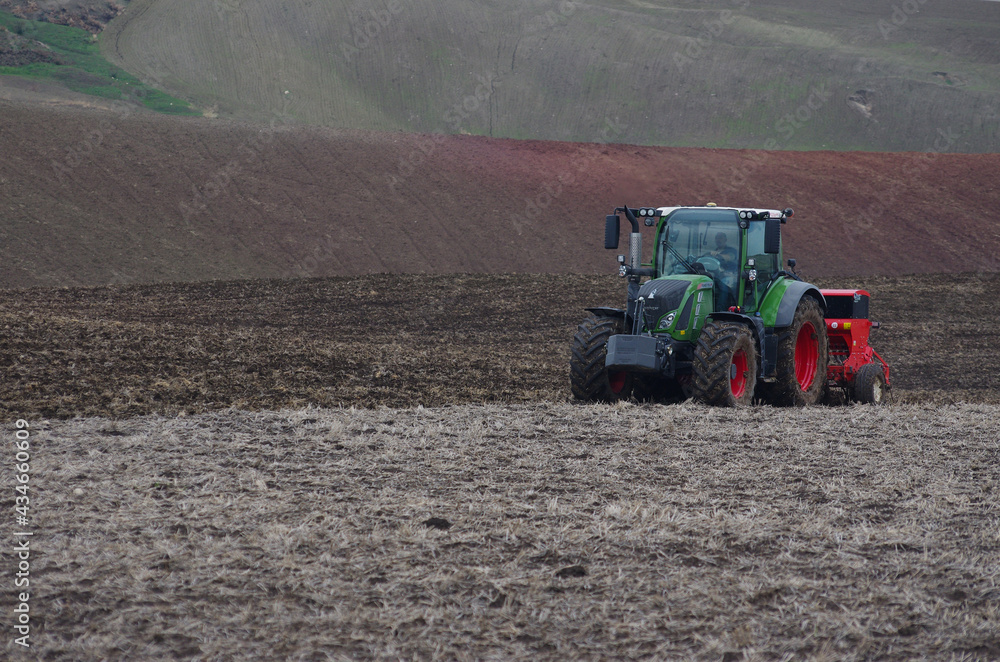 Obraz premium A tractor works the fields before sowing in the countryside of lower Molise