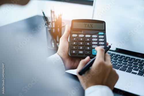 A man calculates taxes with a calculator.