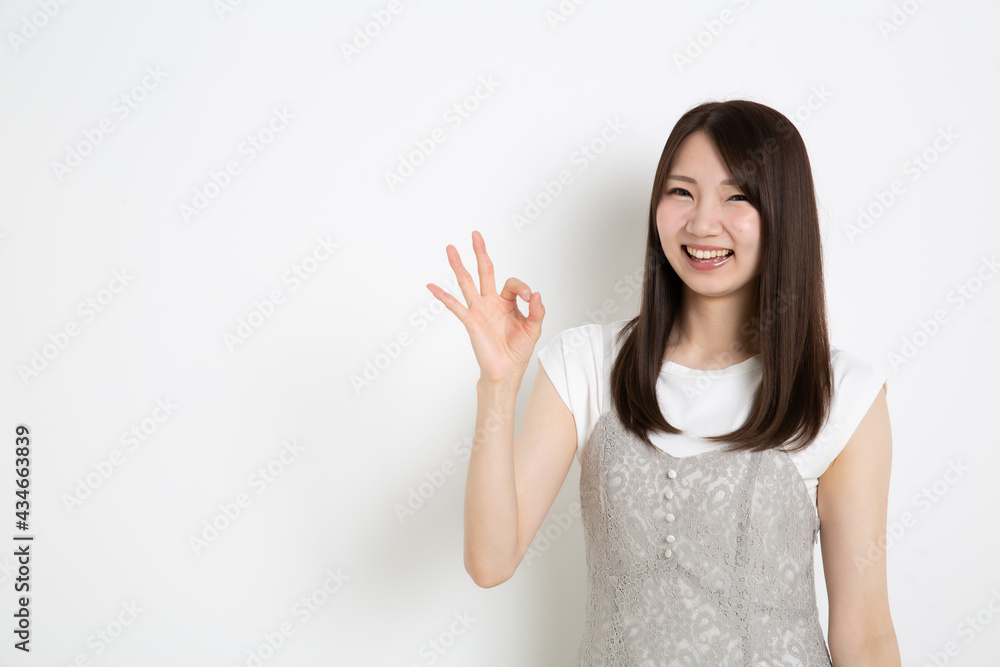 笑顔でオーケーサインをしている若い女性 笑顔でオーケーサインをしている若い女性