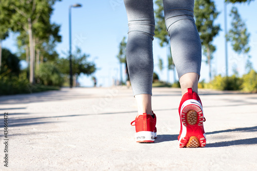 jogging woman with athletic legs and running shoes