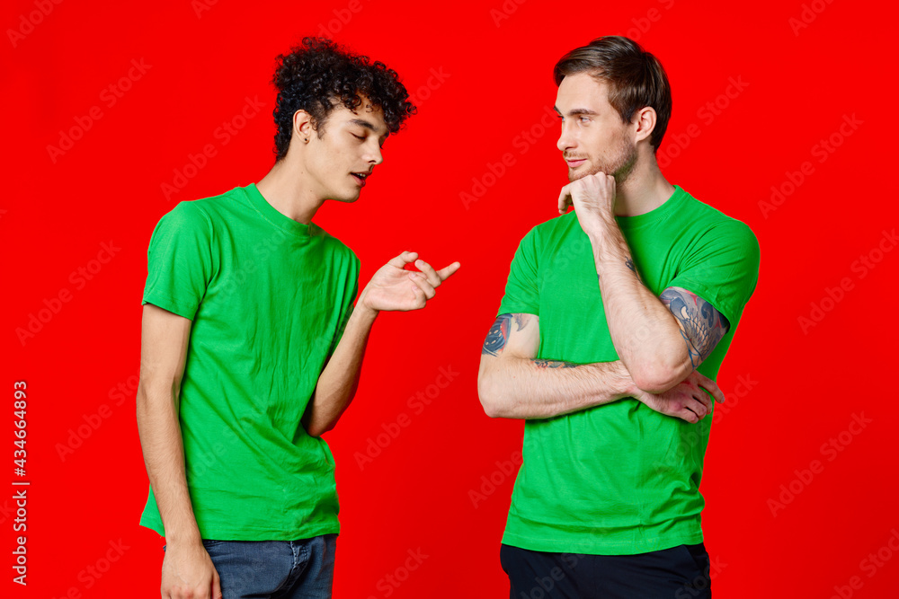two men in green t-shirts are standing side by side communication two men in green t-shirts are standing side by side communication