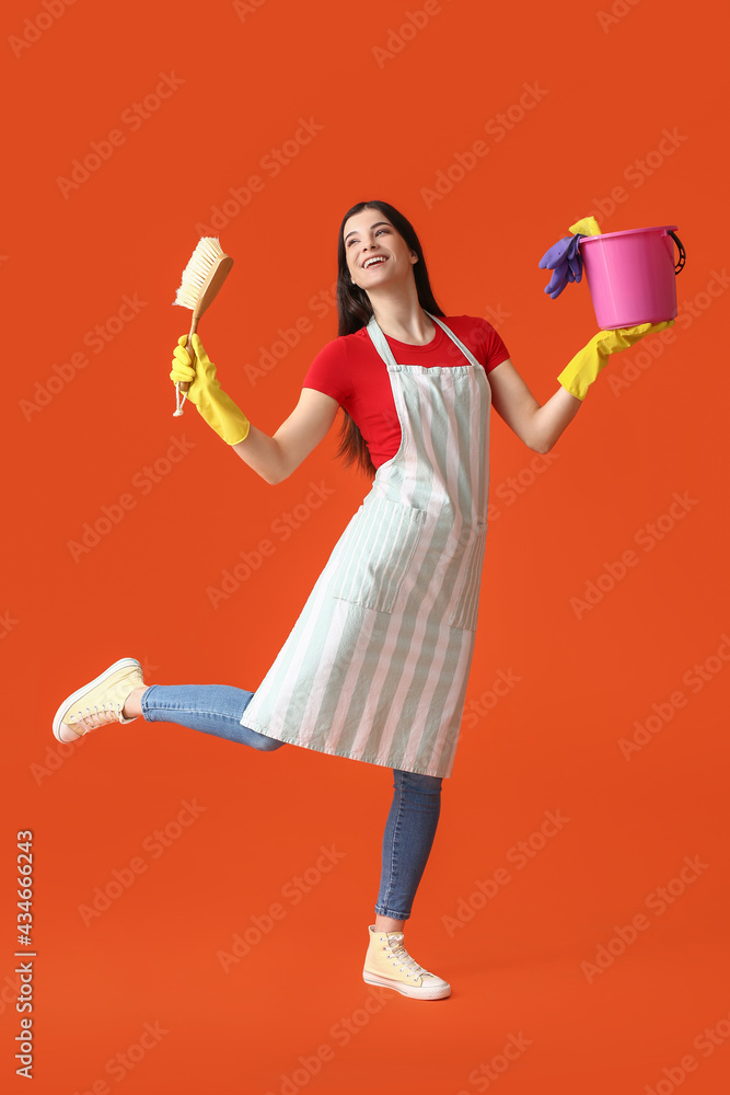 Young woman with cleaning supplies on color background Young woman with cleaning supplies on color background