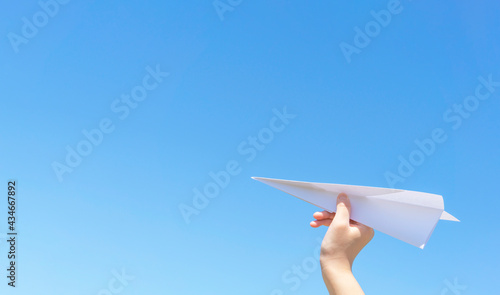 A hand of the child who flies a paper airplane.  紙飛行機を飛ばす子供の手 photo