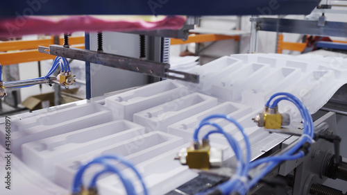 Create plastic package and packing. Machines create packing for bottles. Process of manufacturing plastic containers on extrusion equipment-moving molds and manipulator takes finished product