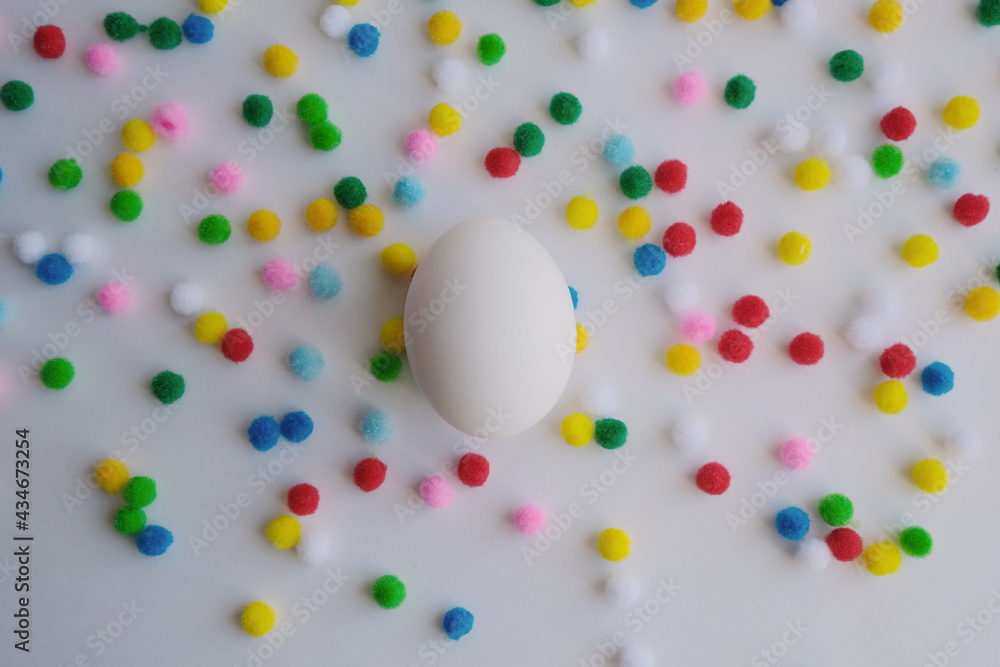 white egg and small yellow, red, green balls