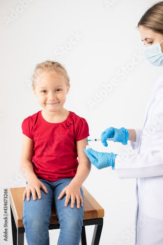 The doctor gives the child an injection of the vaccine.