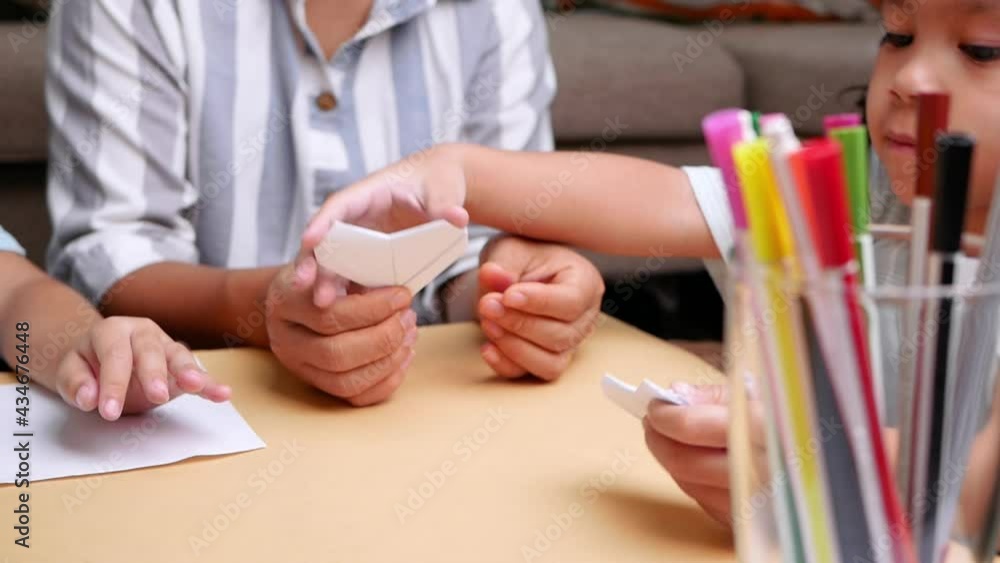 Mother and children learning about The Japanese art of folding paper