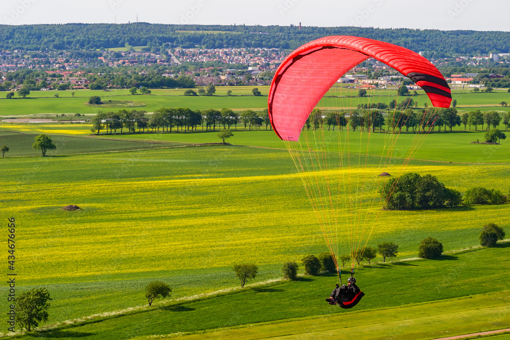 Obraz premium Aerial view at rural landscape with a flying paraglider