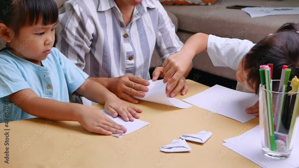 Mother and children learning about The Japanese art of folding paper