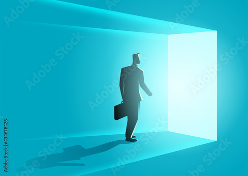 Businessman wallking into bright door