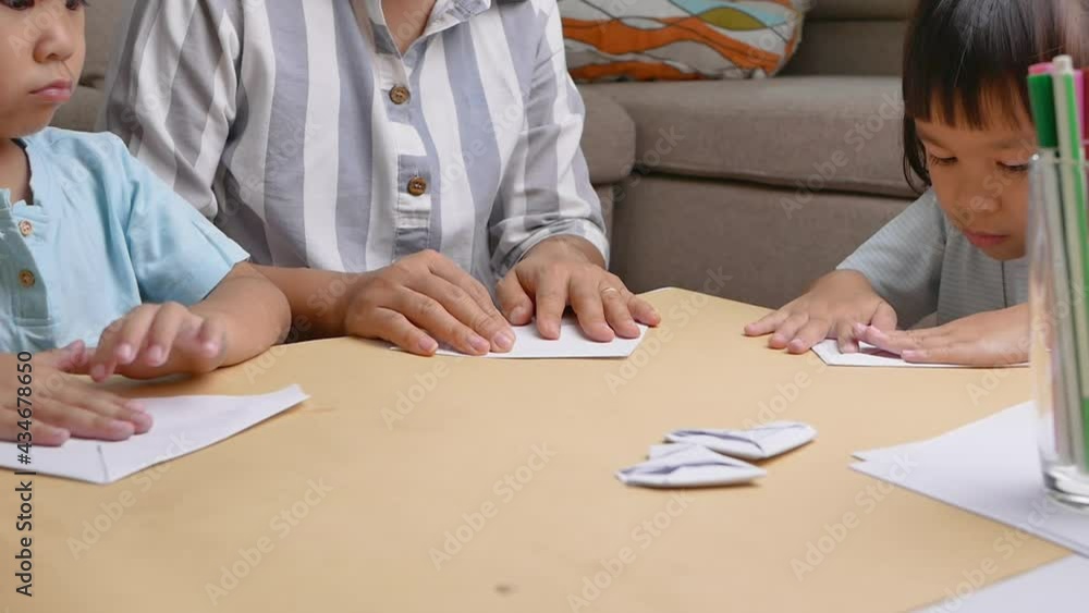 Mother and children learning about The Japanese art of folding paper