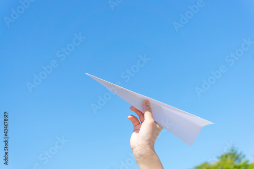 A hand of the child who flies a paper airplane.  紙飛行機を飛ばす子供の手