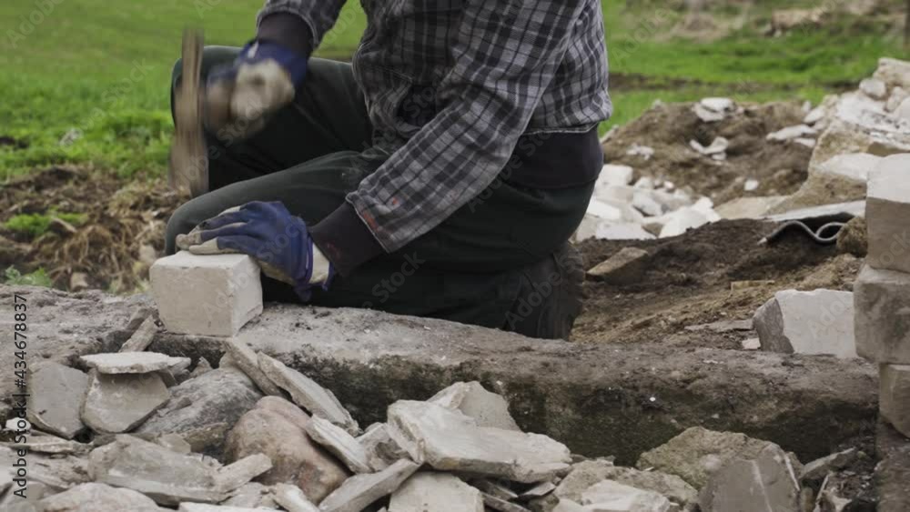 Vidéo Stock Construction worker removing old cement from bricks, close