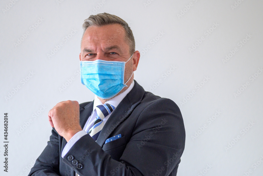 Businessman wearing a suit and face mask giving a greeting Businessman wearing a suit and face mask giving a greeting