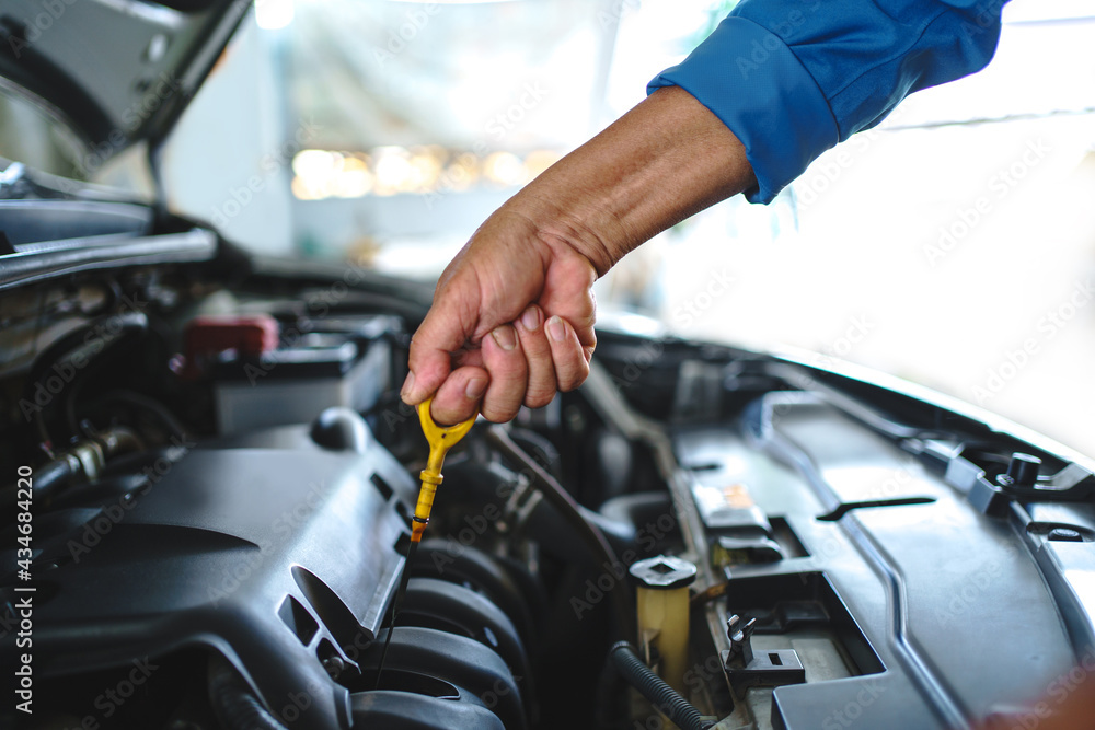 Mechanic to check the oil level. Car service and maintenance concept. Mechanic to check the oil level. Car service and maintenance concept.