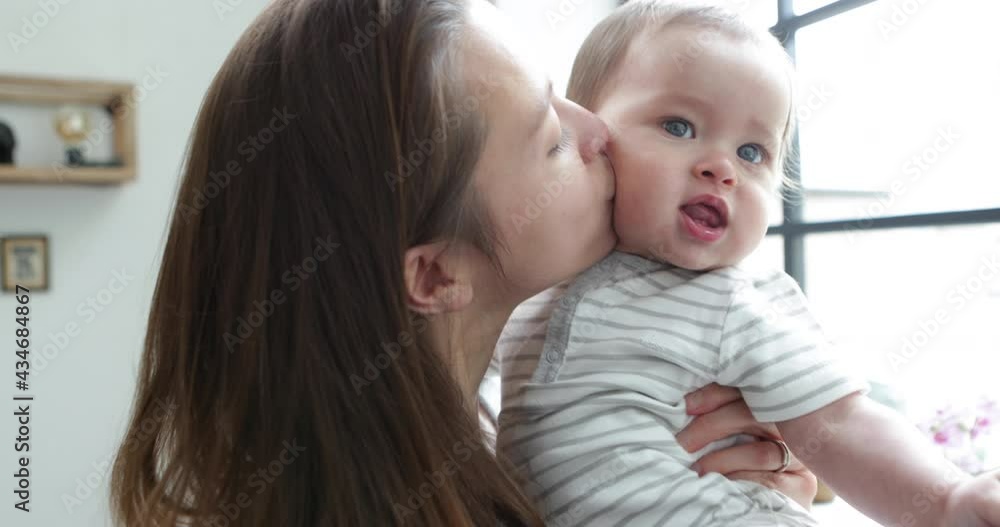 Young mother kissing her baby boy 50fps handheld Young mother kissing her baby boy 50fps handheld