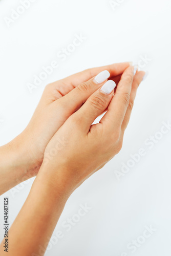 Hands of a young woman close up on a white background