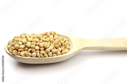 dried peas in a wooden spoon isolated on white background