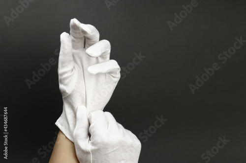 Woman puts on White cotton gloves to moisturize the skin photo