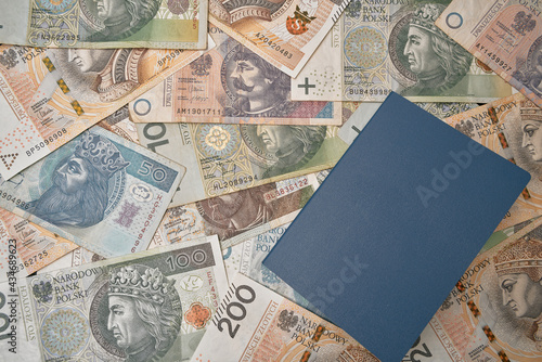 unnamed blue passport on poland national currency. no logo id document and polish zloty. banknotes and individual document