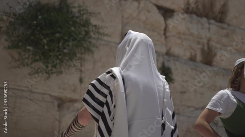 Jewish man pray alone at the wailing wall, Cotel. Strength his believe and faith to god wearing a Tallit and Tefillin. Spirituality act at the sacred holy place in Jerusalem Israel.
