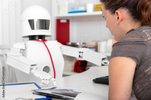 female patient is consultating a ai medicine robot in his office