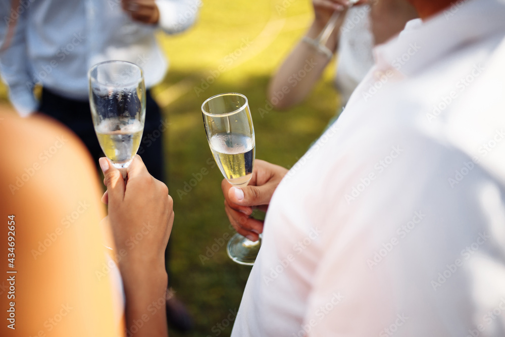 Wedding guests clinking glasses. Group of people enjoying champagne at wedding party. Guests toasting and cheering at stylish celebration. Wedding guests clinking glasses. Group of people enjoying champagne at wedding party. Guests toasting and cheering at stylish celebration.
