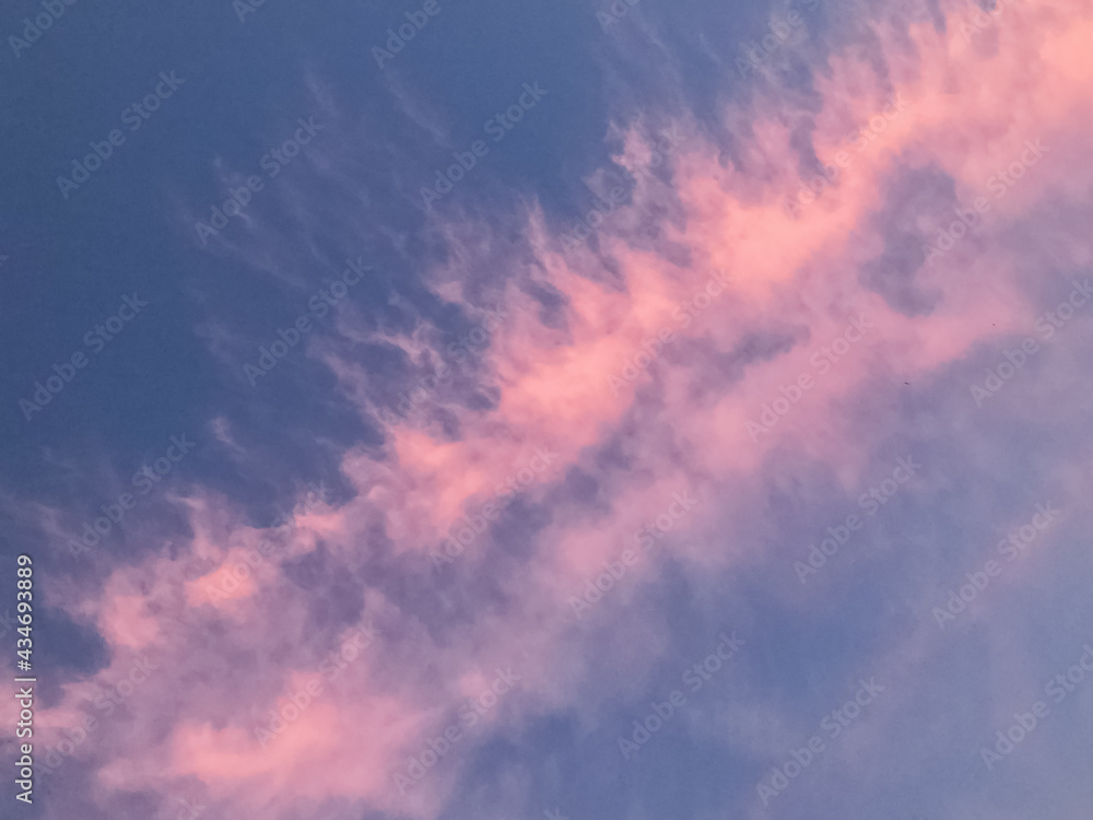 Pink colored sunset clouds on blue sky background