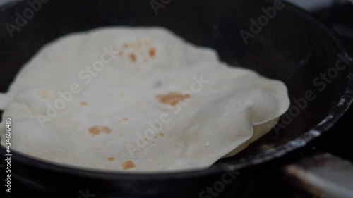 fried wheat round tortilla in a pan with crispy crust