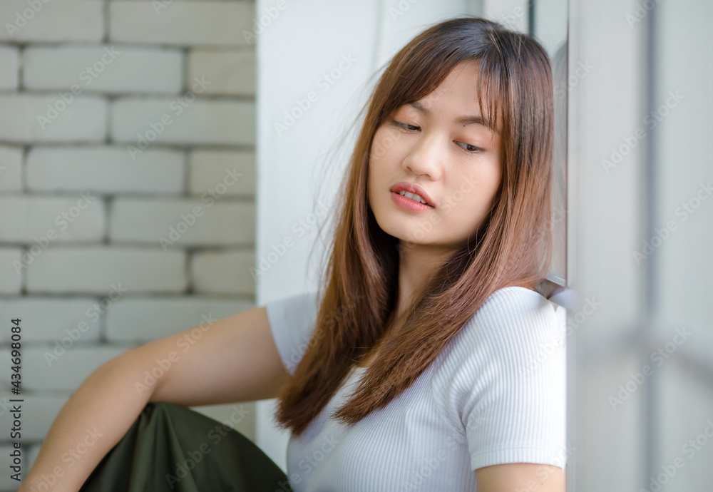 Thoughtful Asian woman looking out of window at home Thoughtful Asian woman looking out of window at home