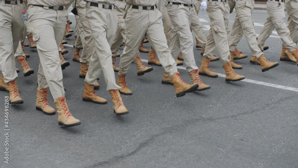 Soldiers in brown uniforms and brown army boots are marching . Soldiers in brown uniforms and brown army boots are marching .